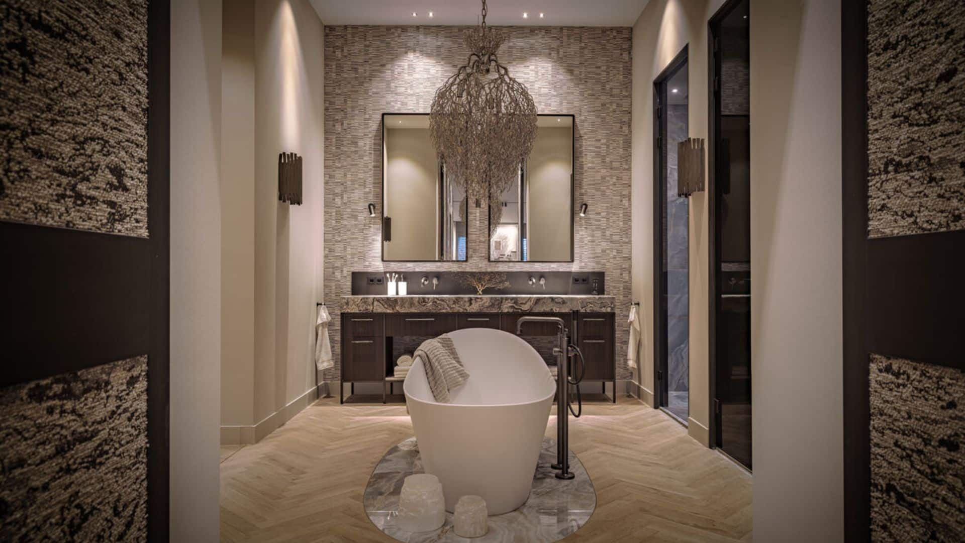 Badkamer met vrijstaand bad en op maat gesneden omlijsting van onyx marmer vloertegels