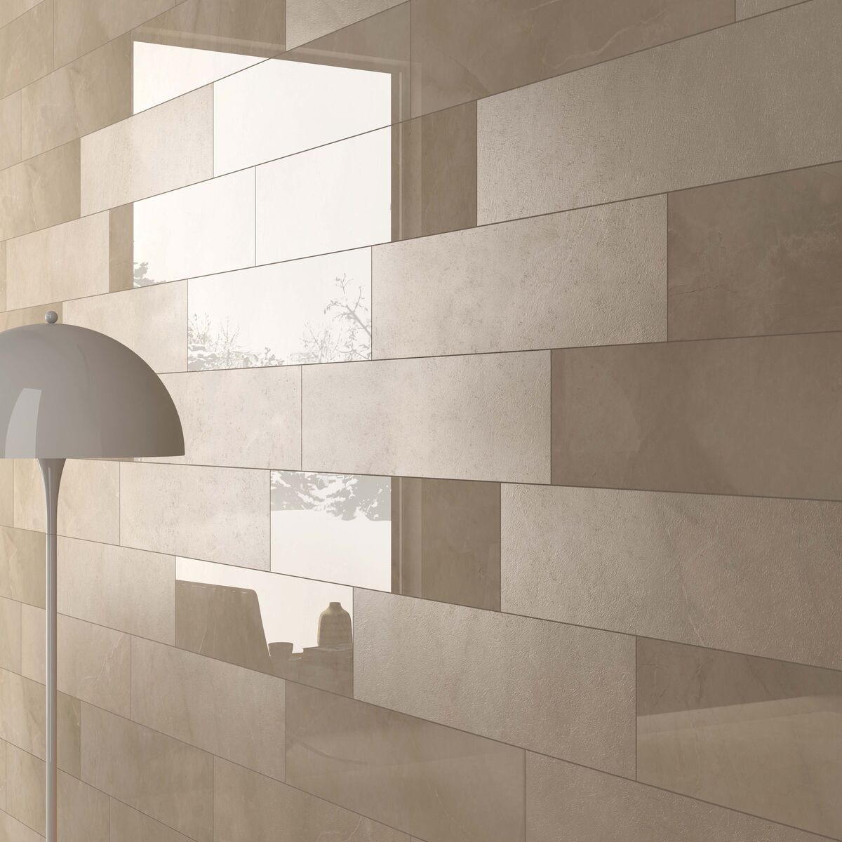 Badkamer met strakke beige wandtegels in een modern patroon, met een witte designlamp en een raam dat natuurlijk licht binnenlaat.